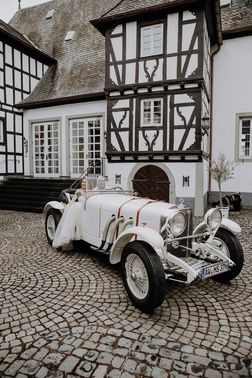 Ehepaar in Oldtimer vor Burg – gesehen bei frauimmer-herrewig.de