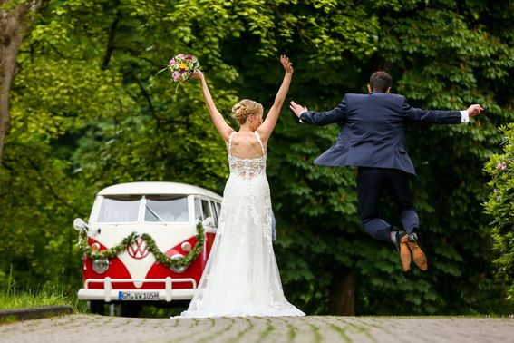 Braut vor rotem VW Bulli – gesehen bei frauimmer-herrewig.de
