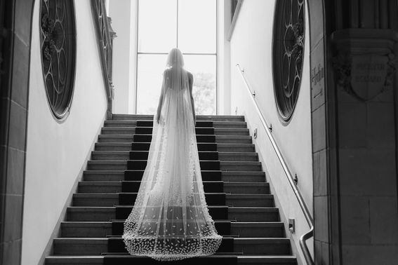 Braut mit langem Schleier geht Treppe hinauf – gesehen bei frauimmer-herrewig.de