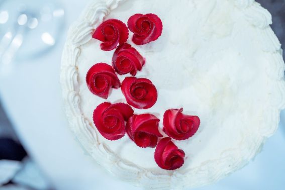 weiße Hochzeitstorte mit roten Rosen – gesehen bei frauimmer-herrewig.de