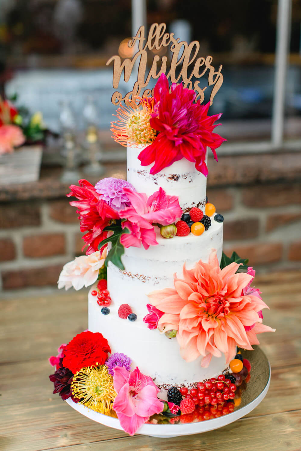 Bunte Hochzeitstorte mit floralen Akzenten – gesehen bei frauimmer-herrewig.de